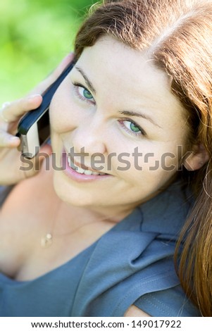 Beautiful Caucasian young woman close-up portrait speaking on phone