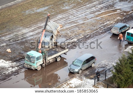 SAINT-PETERSBURG, RUSSIA - CIRCA FEBRUARY, 2014: Tow truck loads banding after the strong road crash freight car for scrappage. Government scrappage scheme