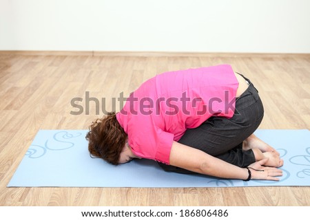 Young woman lying on the mat in one of the yoga positions
