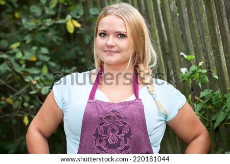 Half-length portrait of country smiling Caucasian woman in apron