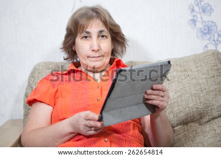 Middle age Caucasian woman holding tab and looking at camera