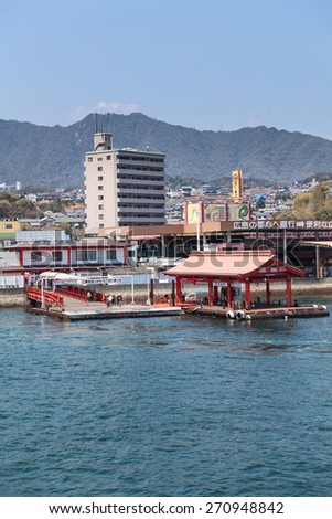 MIYAJIMAGUCHI, JAPAN - CIRCA APR, 2013: Ferry pier of JR transportation company is in Miyajimaguchi port. View from departing vessel. Two ferry-boats for Itsukushima island travel in Hiroshima gulf.
