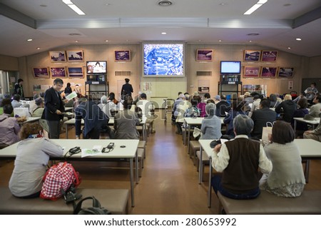 TOKYO, JAPAN - CIRCA APR, 2013: Tourists watch video in Someikan waiting room before walking tour in Tokyo Imperial Palace ground. Tokyo Imperial Palace is the main residence of the Emperor of Japan