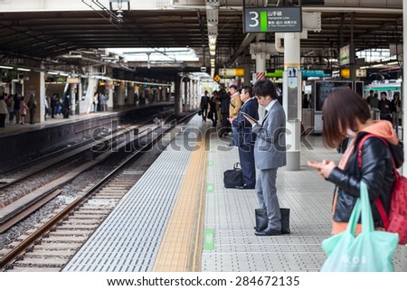 TOKYO, JAPAN - CIRCA APR, 2013: Passengers wait for train arrival on the Japanese rail station at Yamanote line. The Yamanote is a railway loop line in Tokyo, Japan