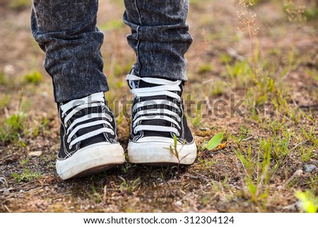 Running rubber shoes are on the legs, person standing on earth