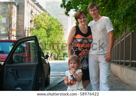 Happy parents near a new car and child here