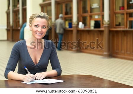 Women\'s hands with a handle filling the form on the desk in the office