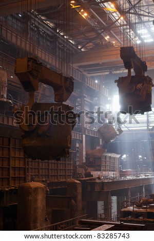 Steelmaking ladles on crane hanging on steel mill. Iron metallurgy works