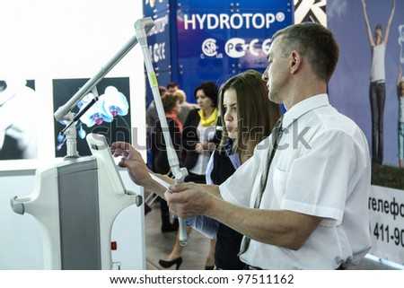 MOSCOW - OCTOBER 26: Man shows work laser device at the international exhibition of professional cosmetics and beauty salon equipment INTERCHARM on October 26, 2011 in Moscow