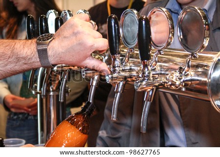 MOSCOW-APRIL 27: Pouring beer to glass from beer tap at the international exhibition of market production beer, and low alcohol drinks Brewer on April 27, 2011 in Moscow