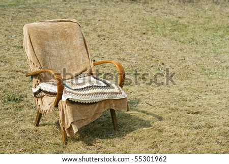old-fashioned garden chair with a textile cover and wool pillow