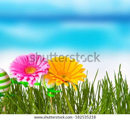 Beautiful meadow, easter eggs and flower with blue sky. Easter concept. Fresh green grass. Color easter eggs. Tulips and daisy.