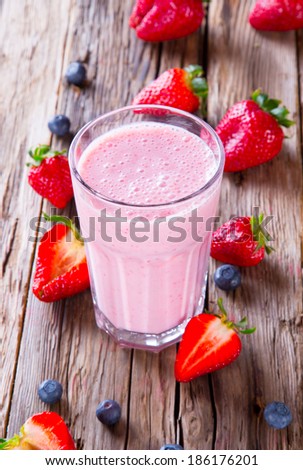 Fresh milk, strawberry drink on wodeen table, assorted protein cocktail with fruits.