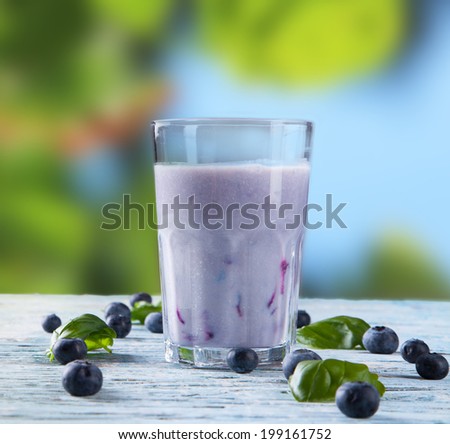 Fresh milk, raspberry and blueberry drinks on wooden table, assorted protein cocktails with fresh fruits. Natural background.