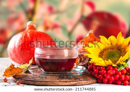 Cup of tea with autumn leaves with season vegetable on wooden table