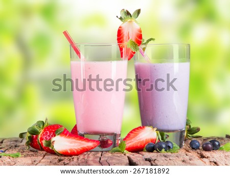 Fresh milk, strawberry, blueberry drinks on wooden table, assorted protein cocktails with fresh fruits.
