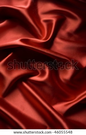 textile red satin background draped in waves