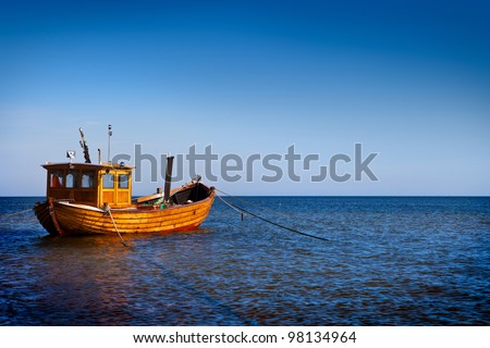 Fishing boat floating on the water, blue sea and sky with copyspace