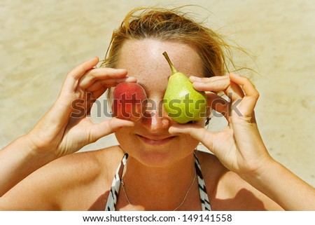 Freckled young woman with peach and pear.