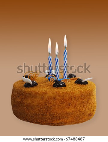 Cake chocolate and three candles isolated on brown background.