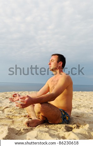 Young man is meditation at the sea.