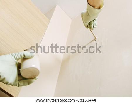 Man painting wall by pastel color.
