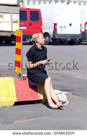 HELSINKI, FINLAND, CIRCA 2014 - Customs service woman sitting on the construction during the work break circa 2014 in Helsinki, Finland