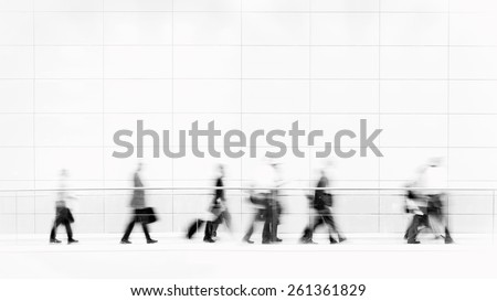 Group of unrecognizable business people in front of modern architecture, blurred motion, monochrome photo