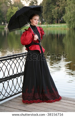 Pretty girl in a historical dress with an umbrella