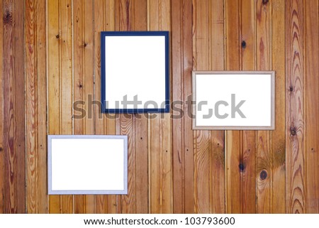On the old yellow rural home wall of pine wood planks hung empty white pictures  frames