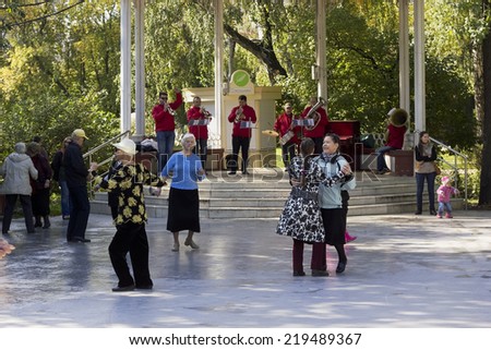 MOSCOW, RUSSIA - SEPTEMBER 20, 2014: Elderly pensioners dance in city park. Plays brass band. Solar autumn Saturday morning.