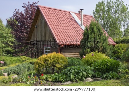 Standard no name wooden rural  shed with red tile roof  in the European decorative garden landscape. Sunny day