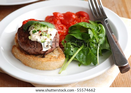 Burger on toast with spinach and tomatoes