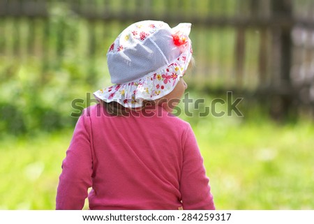little girl looks back at the park