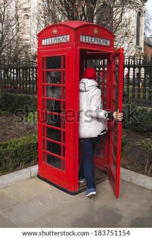 Red phone booth in park, London. UK.