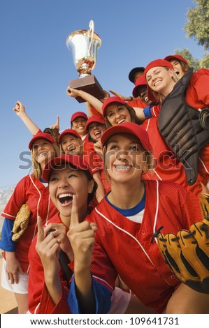Excited young softball team cheering after a winning game