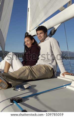 Happy couple on vacation relaxing on sailboat