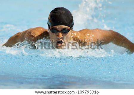 Competitive male swimmer in motion during swimming race