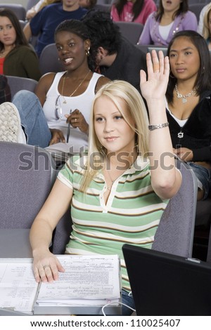 Young female student raising her hand to answer