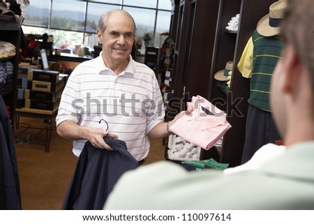 Happy senior man buying clothes in clothing store