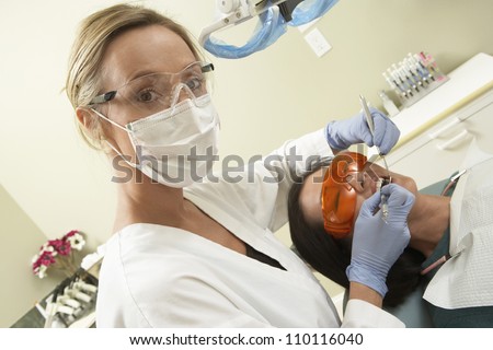 Portrait of female dentist treating patient at clinic