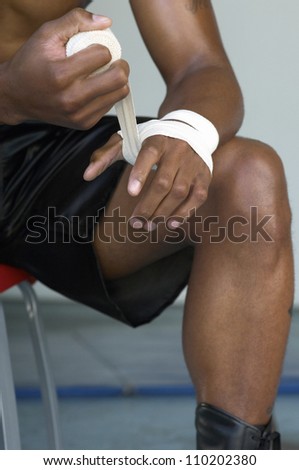 Close-up of a boxer wrapping bandage to his hand