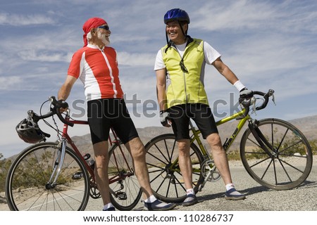Happy male cyclists standing by their bicycles