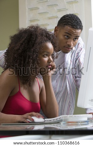 Worried young African American couple working on computer