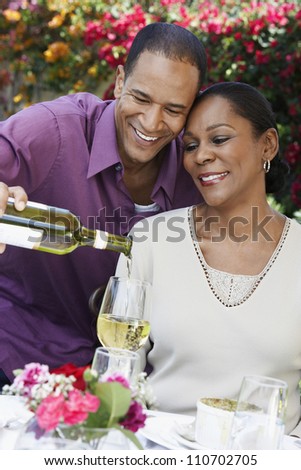 Middle aged African American couple celebrating together with wine