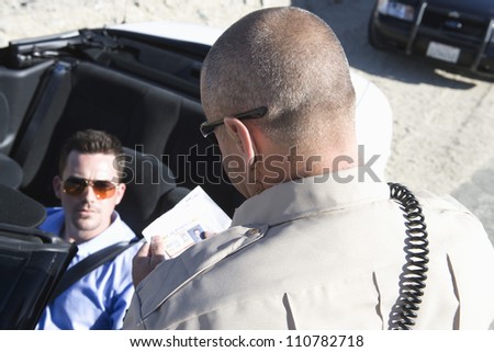 High angle view of traffic officer checking man\'s license