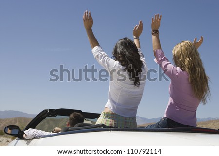 Rear view of happy friends enjoying their journey in car
