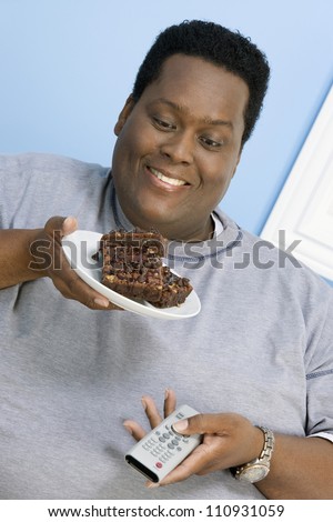 Close-up of African American obese man looking at pastry