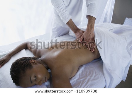 Woman receiving massage at spa from a male masseur