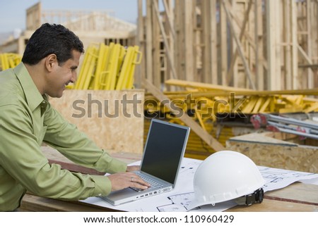 Engineer working on laptop at construction site